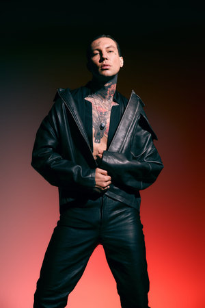 A confident man in bold black leather stands out against a vivid background.