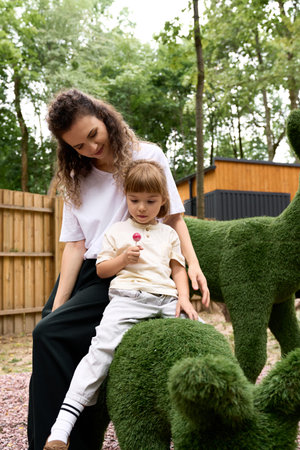 A joyful mother and her adorable daughter explore an amusement park, sharing sweet moments together.の写真素材