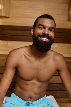 A shirtless Black man with a beard relaxes peacefully in a serene spa.の写真素材