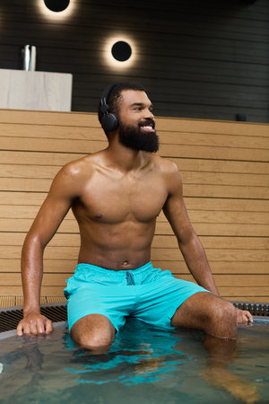 A shirtless African American man with a beard enjoys tranquil moments in a spa setting.の写真素材