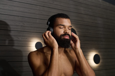 A shirtless man with a beard enjoys peace and relaxation in a soothing spa environment.の写真素材