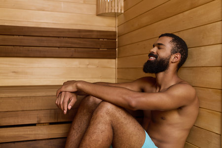 A shirtless African American man with a beard sits peacefully in a spa, embracing relaxation.