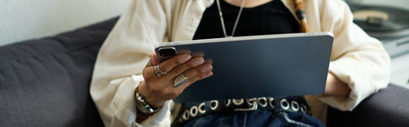 Young woman relaxes at home, engaged in casual activities with her tablet, banner
