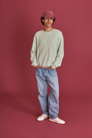 Handsome gentleman stands confidently in a relaxed outfit, exuding effortless style and charm.