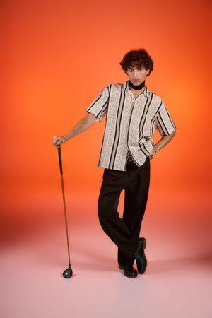 Handsome man showcases fashion flair with a patterned shirt and black trousers, exuding charm.