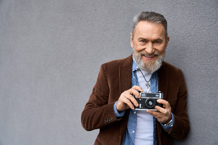 Confident older man with a beard smiles while enjoying urban life near modern building