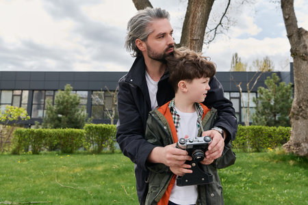 A father with a classic camera shares a sunny day with his excited little son.