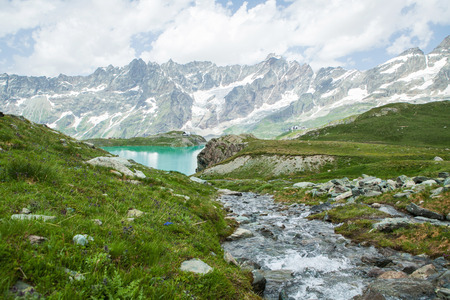 Creek flowing into the lake on a background of mountainsの写真素材