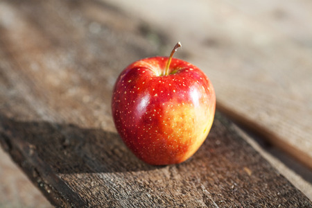 Phorography alone red apple on wooden tableの写真素材
