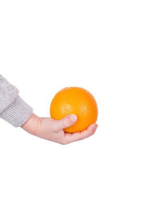 The hand of a little boy holding an orangeの写真素材