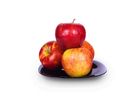 Four ripe red apple on a black plateの写真素材