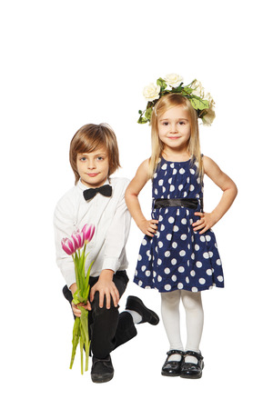 Boy with a bouquet of flowers on her knees beside the girl in a wreathの写真素材