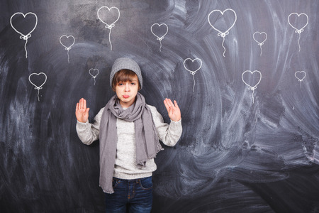 Cute little boy on a gray background and heartsの写真素材