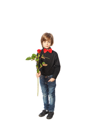 A boy with a red rose in her hand standing on white backgroundの写真素材