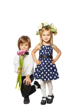 Boy with a bouquet of flowers on her knees beside the girl in a wreathの写真素材