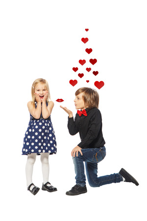 Girl with a rose in her hand standing near the boy on a white backgroundの写真素材