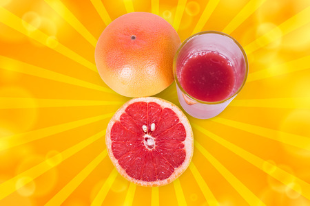 Juicy and ripe grapefruit near Frechet cup on a white backgroundの写真素材