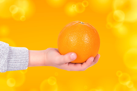 The hand of a little boy holding an orangeの写真素材