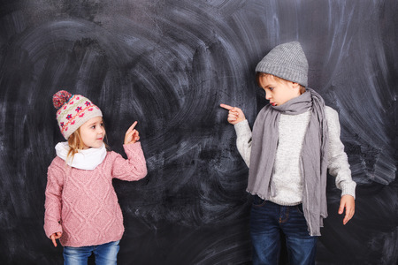 Beautiful boy and girl standing on a gray background. Background is well suited for drawing anything.の写真素材