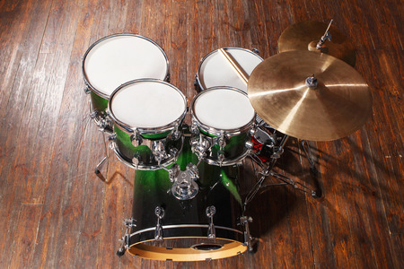 Drum set with green color stands on a brown backgroundの写真素材