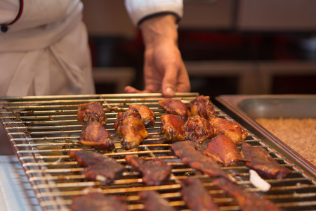 Cook on the grill prepares delicious chicken wingsの写真素材