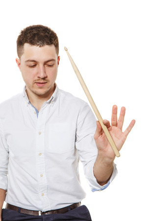 A guy with a drumstick in hand teaches how to keep it on a white の写真素材