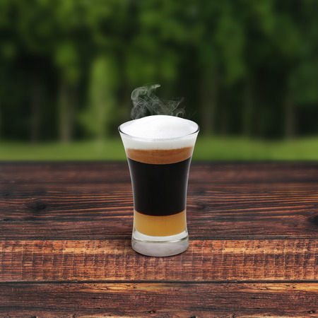 Mocha coffee on wooden table around tree
