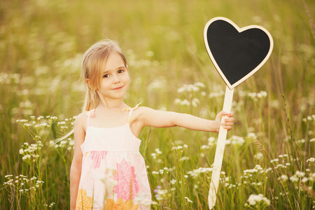 Cute little girl with plate loveの写真素材