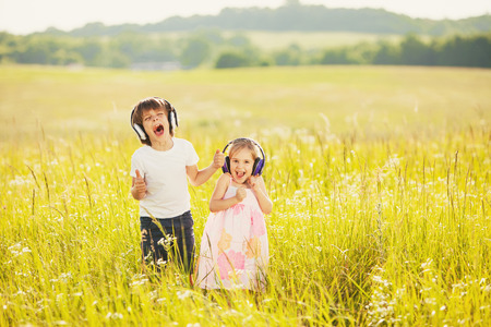 Happy kids listen music on natureの写真素材