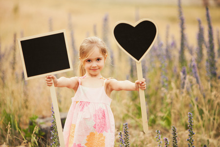 Cute little girl with plate love and square on natureの写真素材