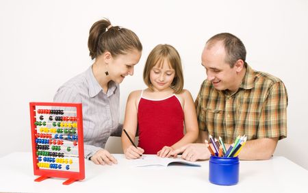 A happy family sitting together. the parents are helping their little daughter with the homework...