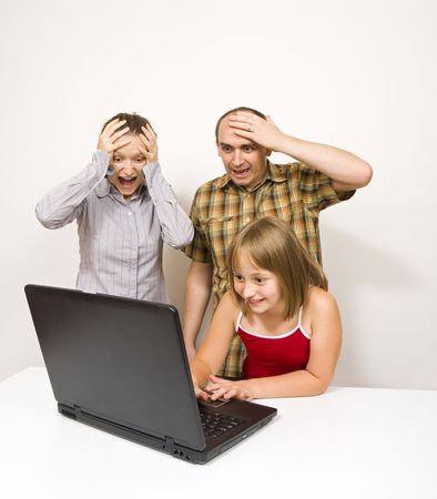 A cute little girl using a laptop, watching something shocking for the parents - an illlustration of dager that threathens the children if they use the internet uncontrolled.の写真素材