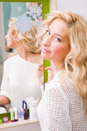 A young woman in front of the mirror smiling.の写真素材