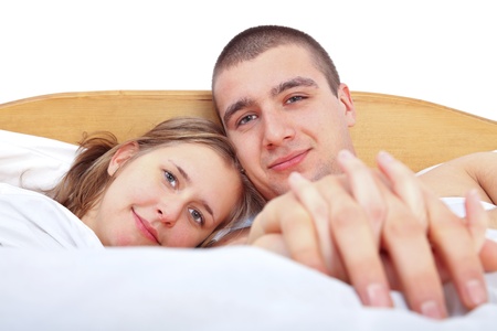 Happy man and woman laying in bed smiling and loving each other.の写真素材