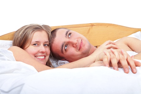 Happy man and woman laying in bed smiling and loving each other.の写真素材