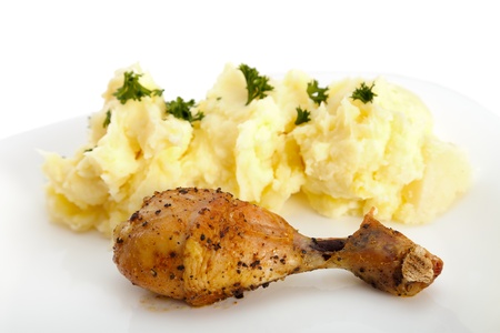 Mashed potato with a fried, crunchy chicken leg on a white plate.の写真素材