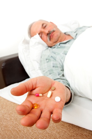 Elderly man with drugs in bad.の写真素材