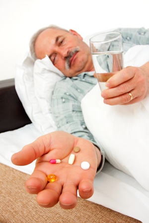 Elderly man with drugs in bed.の写真素材