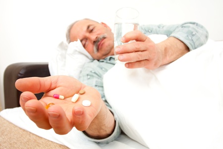 Elderly man with drugs in bad.の写真素材