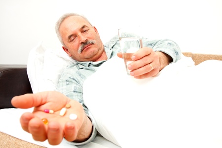 Elderly man with drugs in bad.の写真素材