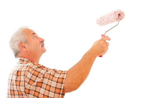 Senior man painting the white wall with roll brush.の写真素材