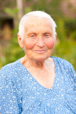 Kind elderly lady with blue blouse outdoorsの写真素材