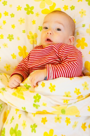 Cute baby boy laying in bed.の写真素材