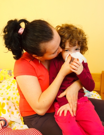 Mother blowing her daughter's nose.の写真素材