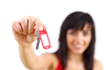 Happy young woman smiling and showing keys with tag to her new home.