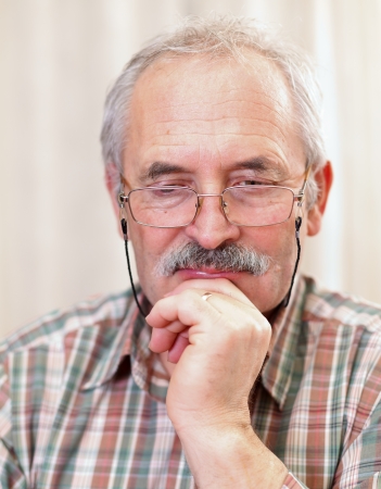 Portrait of an attentive senior man with glasses.の写真素材