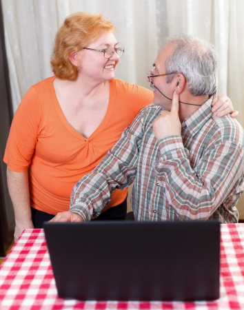Elderly couple hugging each other at home.の写真素材