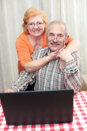 Elderly couple hugging each other at home.の写真素材