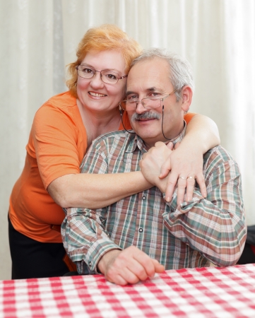 Elderly couple hugging each other at home.の写真素材