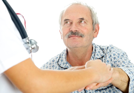 Doctor holding hand of senior man, patient looking at the doctor.の写真素材